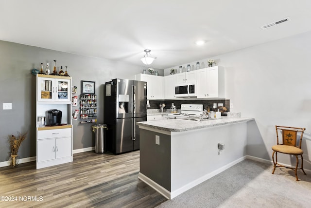 kitchen featuring a peninsula, white appliances, visible vents, white cabinetry, and light countertops