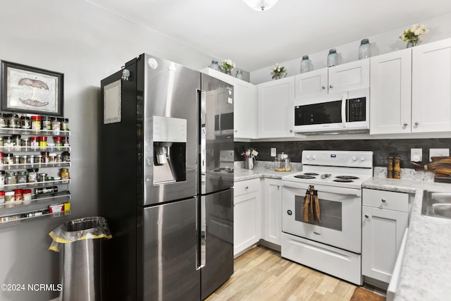 kitchen featuring white appliances, light countertops, light wood finished floors, and white cabinetry