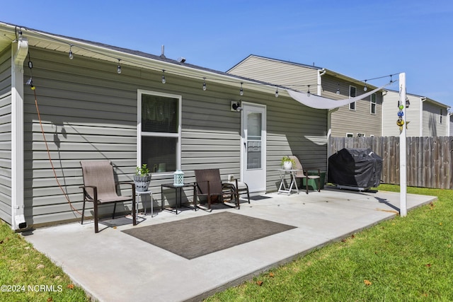 rear view of property featuring fence and a patio