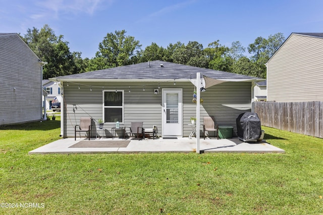 back of property with a yard, fence, and a patio