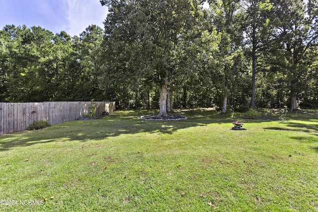 view of yard featuring fence and a fire pit