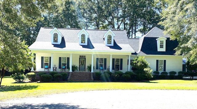 new england style home featuring a front lawn and covered porch