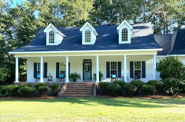 cape cod-style house featuring a front lawn and covered porch