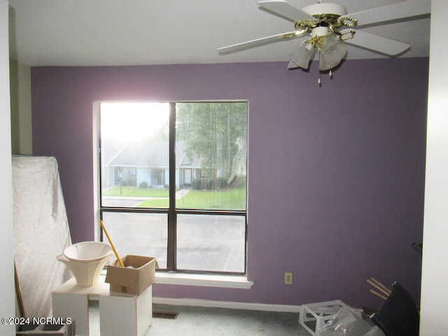 carpeted bedroom featuring multiple windows and ceiling fan