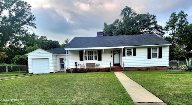 view of front of property featuring a front yard, a garage, and covered porch