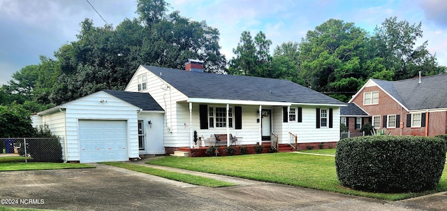 view of front of property featuring a garage, covered porch, and a front yard