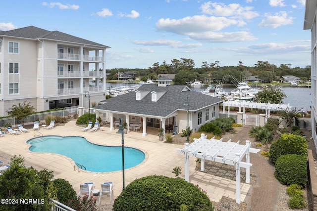 view of swimming pool with a water view and a patio