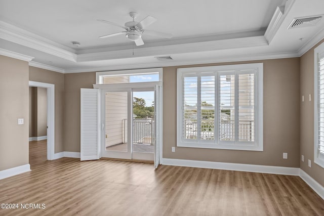 spare room featuring ceiling fan, a raised ceiling, light hardwood / wood-style floors, and crown molding