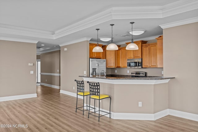 kitchen featuring light wood-type flooring, dark stone countertops, ornamental molding, and appliances with stainless steel finishes