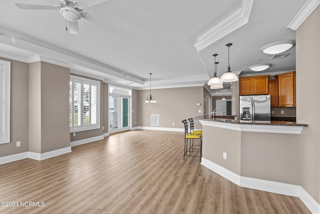 kitchen featuring hanging light fixtures, ceiling fan with notable chandelier, light hardwood / wood-style flooring, and stainless steel fridge with ice dispenser