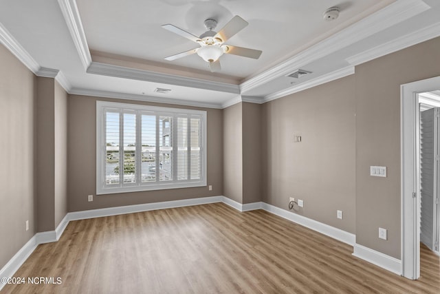 unfurnished room with a tray ceiling, ceiling fan, wood-type flooring, and ornamental molding