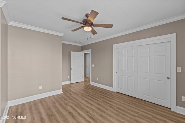 unfurnished bedroom featuring a closet, ceiling fan, light hardwood / wood-style floors, and crown molding