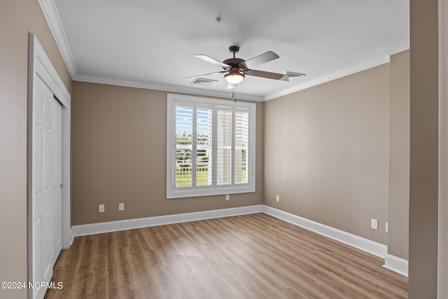 unfurnished bedroom with ornamental molding, hardwood / wood-style flooring, ceiling fan, and a closet