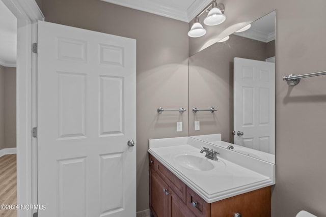 bathroom with ornamental molding, vanity, and wood-type flooring