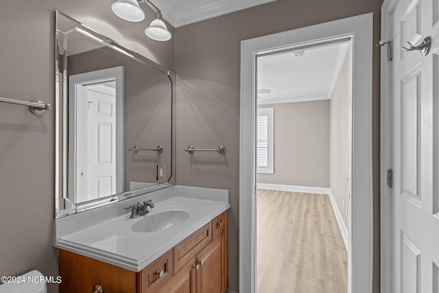 bathroom with crown molding, vanity, and wood-type flooring