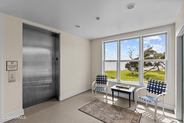 sitting room featuring a healthy amount of sunlight and elevator