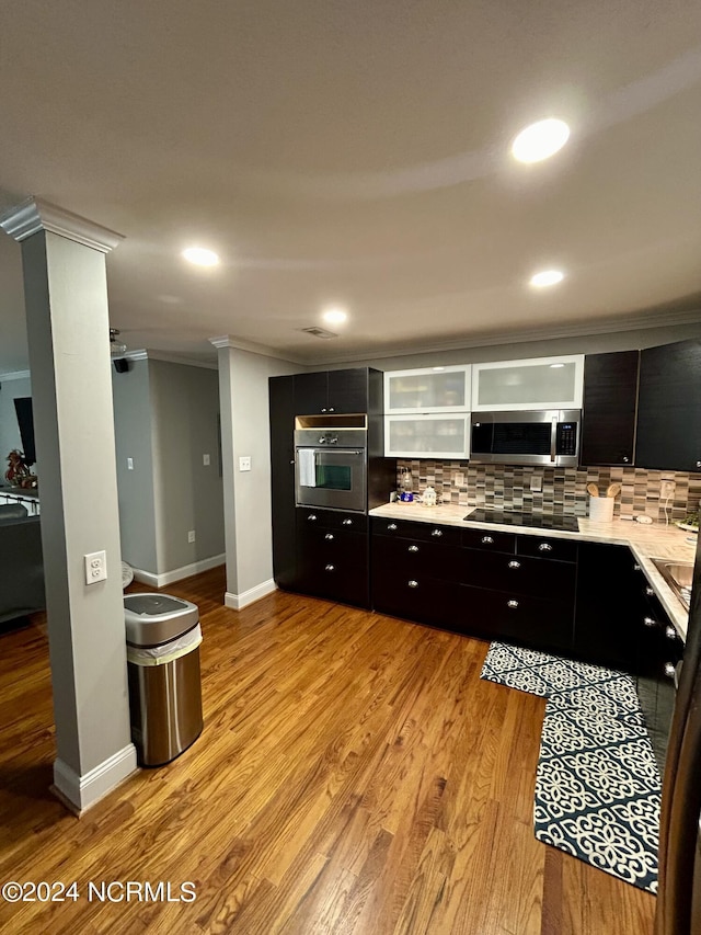 kitchen with appliances with stainless steel finishes, light wood-style flooring, and decorative backsplash