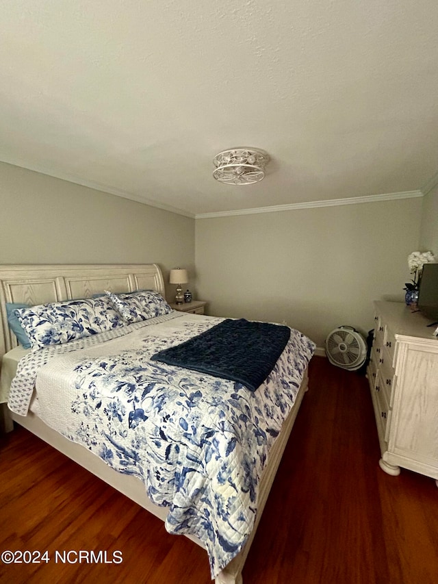 bedroom featuring ornamental molding and dark hardwood / wood-style floors