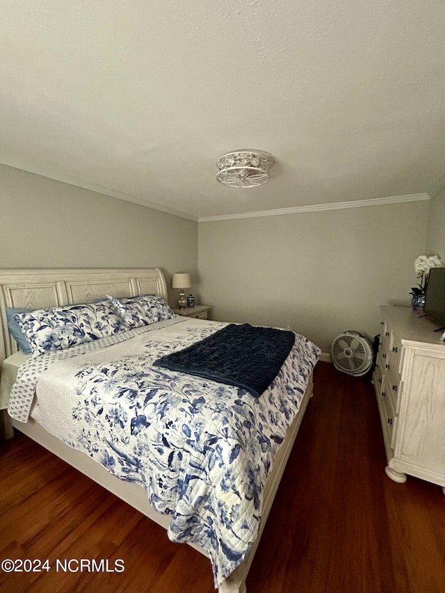 bedroom with dark wood-style flooring and crown molding