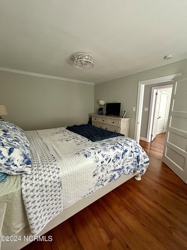 bedroom with wood-type flooring and crown molding