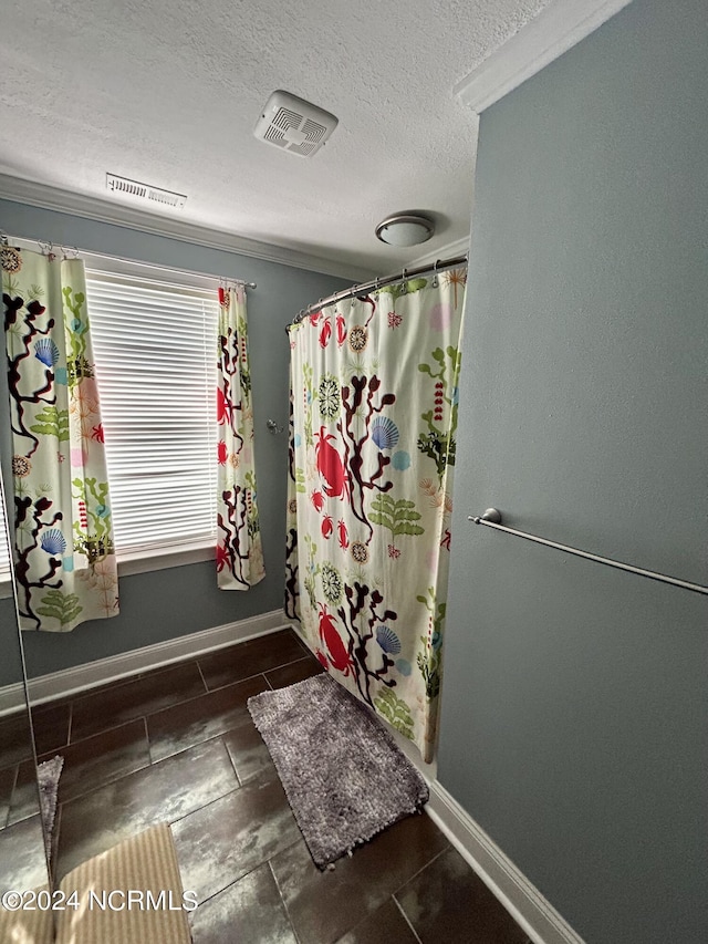 bathroom featuring baseboards, visible vents, and a textured ceiling