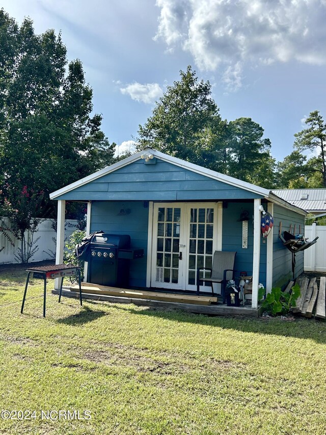 back of property with a yard and french doors