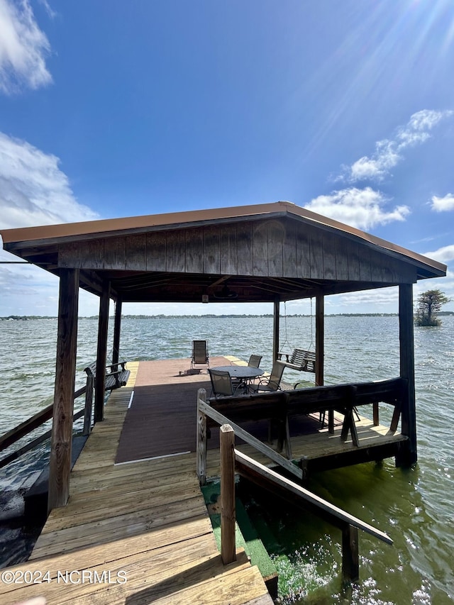 dock area with a water view and boat lift