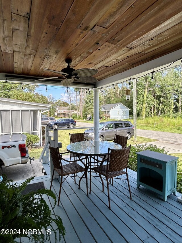 wooden terrace featuring a ceiling fan and outdoor dining area