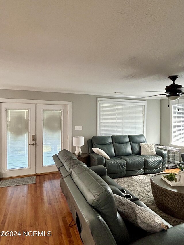 living room featuring a textured ceiling, dark wood-type flooring, ceiling fan, and french doors