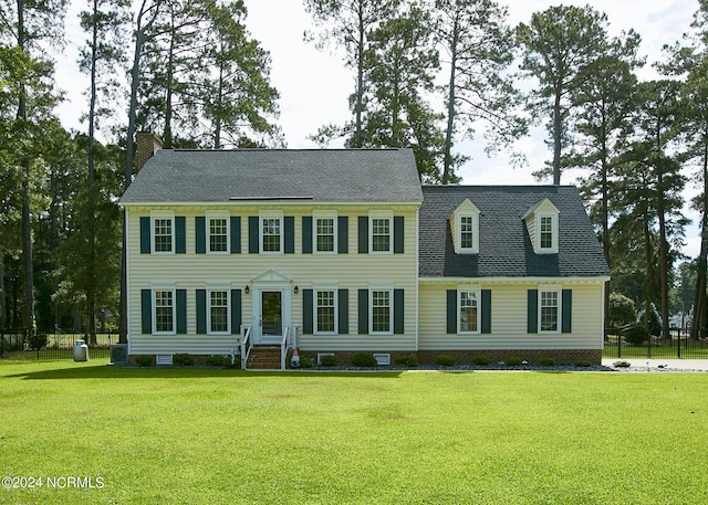 colonial house featuring crawl space, central AC, and a front yard