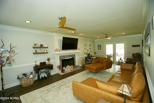 living area with crown molding, recessed lighting, ceiling fan, wood finished floors, and a tile fireplace