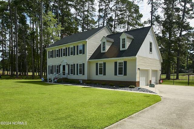 view of front of home with a garage, concrete driveway, roof with shingles, fence, and a front yard