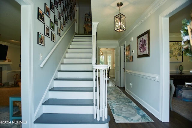 staircase featuring crown molding and wood finished floors