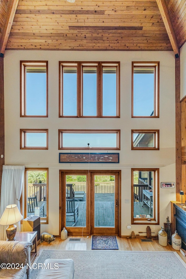 living area with wood ceiling, high vaulted ceiling, beam ceiling, and wood finished floors