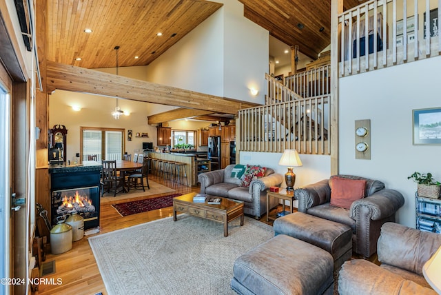 living area featuring wood ceiling, wood finished floors, stairs, high vaulted ceiling, and recessed lighting