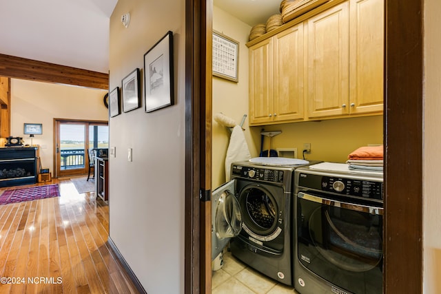 washroom featuring cabinets, hardwood / wood-style flooring, and washer and dryer