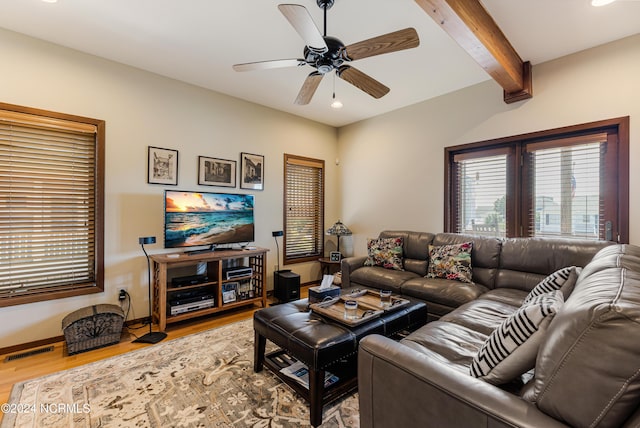 living area featuring baseboards, visible vents, ceiling fan, wood finished floors, and beam ceiling