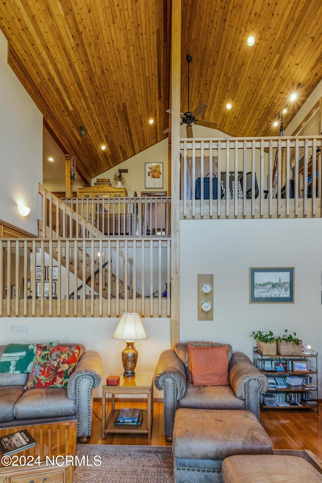 living area with wooden ceiling, stairs, high vaulted ceiling, and wood finished floors