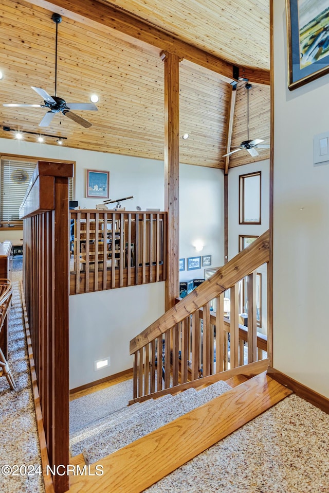 stairway with beamed ceiling, ceiling fan, wood ceiling, and high vaulted ceiling