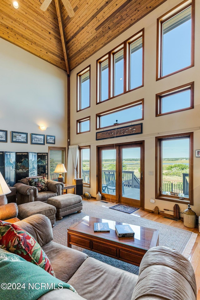 living area featuring high vaulted ceiling, wood finished floors, wood ceiling, and a healthy amount of sunlight