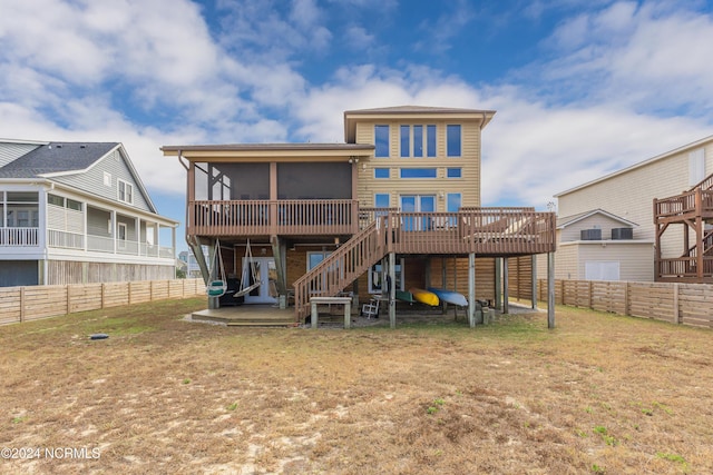 back of property with a deck, a patio, a fenced backyard, a sunroom, and stairway