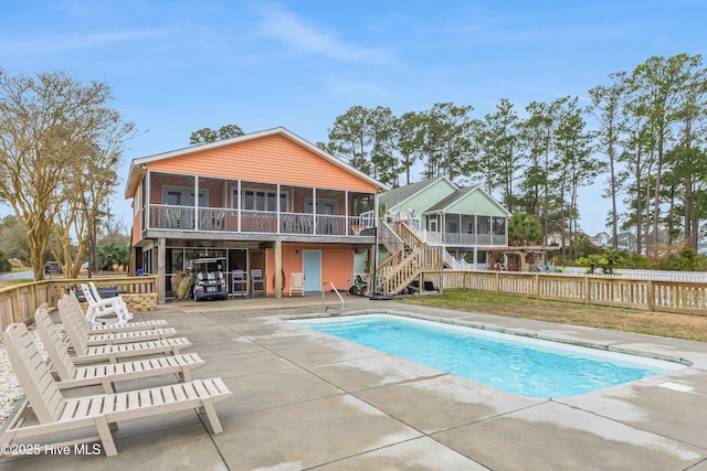 view of pool with a patio area and a sunroom