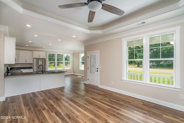 kitchen featuring visible vents, dark countertops, freestanding refrigerator, a peninsula, and white cabinetry