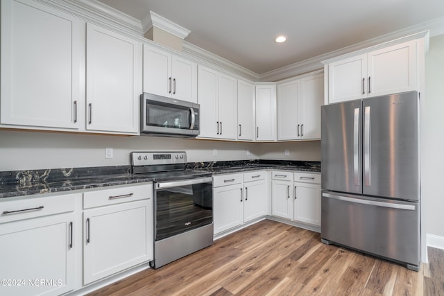 kitchen featuring dark stone counters, stainless steel appliances, light wood-type flooring, white cabinetry, and recessed lighting