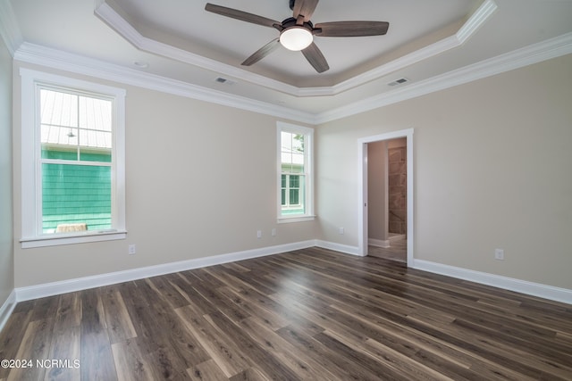 unfurnished room with dark wood-style floors, a tray ceiling, visible vents, and baseboards