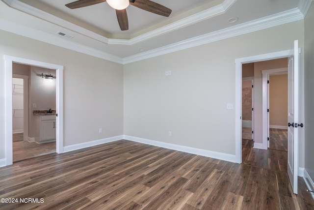 spare room featuring a tray ceiling, crown molding, visible vents, and dark wood-type flooring