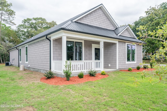 view of front of house featuring a front lawn, covered porch, and central air condition unit