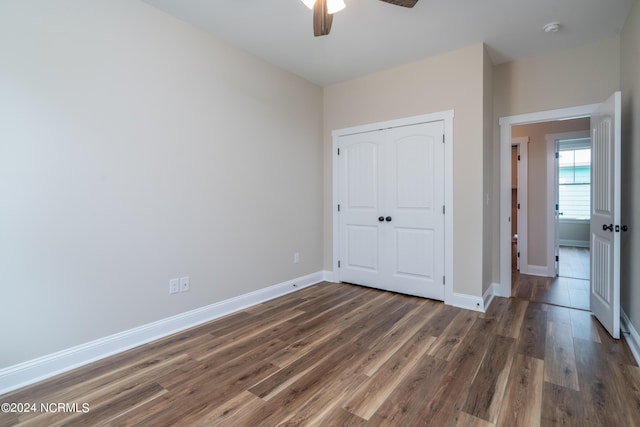 unfurnished bedroom featuring ceiling fan, a closet, baseboards, and wood finished floors