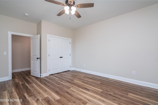 unfurnished bedroom with ceiling fan, a closet, baseboards, and wood finished floors