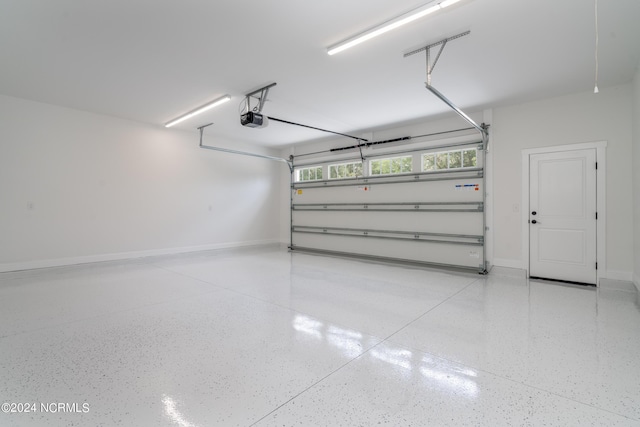 garage featuring a garage door opener and baseboards